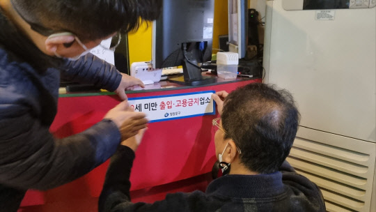 단속반이 청소년 출입금지 스티커를 부착하고 있다.  <사진=서울시>